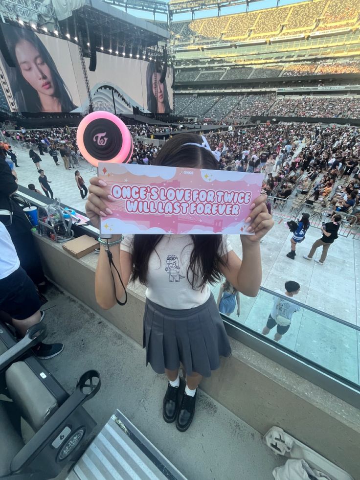 a girl holding up a sign in front of an audience