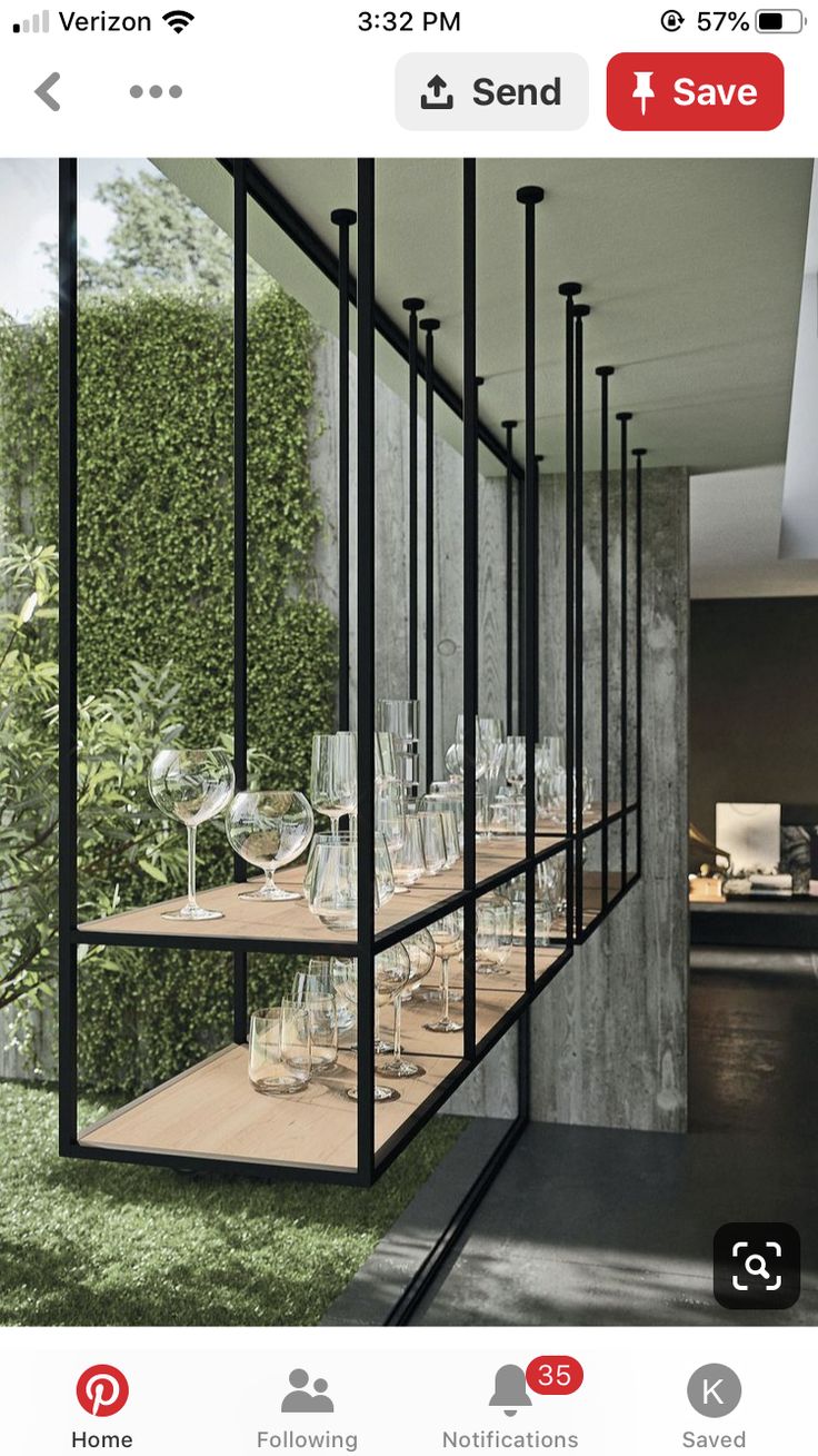 a set of wine glasses sitting on top of a wooden shelf next to a green wall