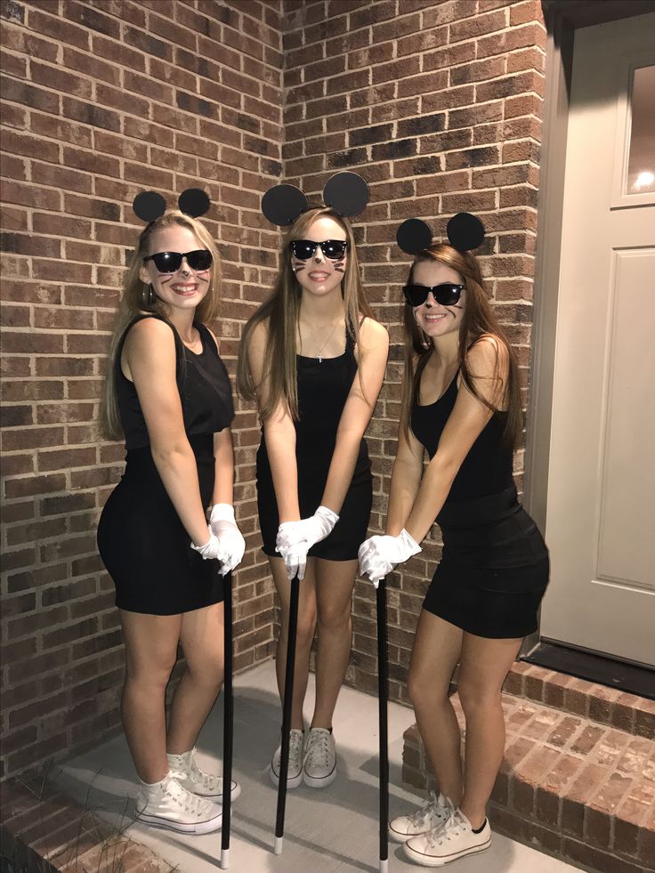 three girls dressed up as mickey mouse and minnie mouse ears, posing for the camera