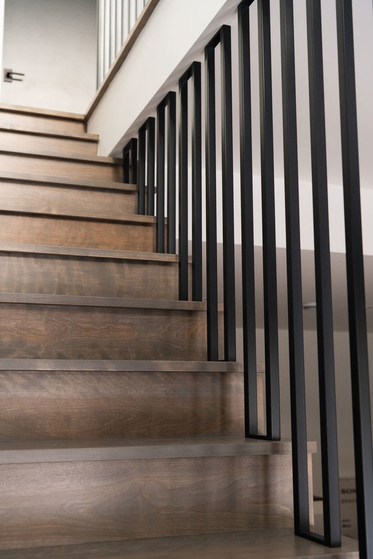 a set of wooden stairs with black railings