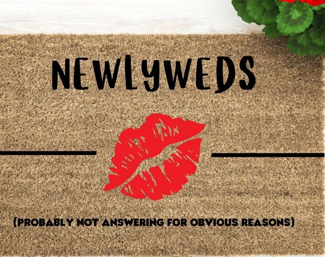 a door mat with the words newlyweds and a red lipstick imprint on it