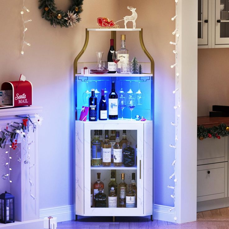 a lighted bar cart with bottles of wine in front of a christmas wreath on the wall