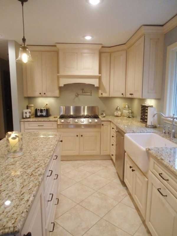 a kitchen with white cabinets and marble counter tops