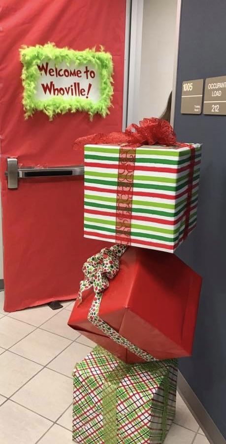 two wrapped presents sitting on top of each other in front of a red and green door