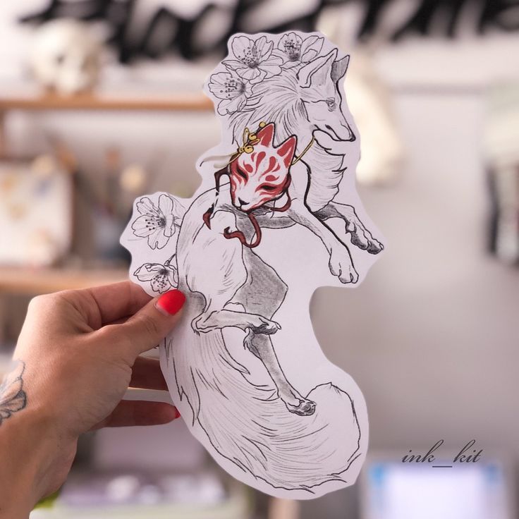 a person holding up a sticker with a drawing on it