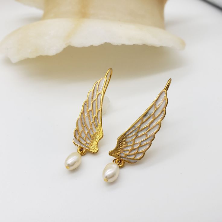 These ornate Swan Wing Earrings will add an elegant touch to any outfit. With delicate detail, they have the power to make a statement and turn heads. Perfect for any occasion. Materials: pewter with gold finish, epoxy, freshwater pearl drop Length: 1 3/4" Gift box included From the collections of the Rijksmuseum, Amsterdam Gold Plated Metal Pearl Earrings, Gold Metal Pearl Earrings, Gold-tone Metal Drop Pearl Earrings, Gold-tone Metal Pearl Drop Earrings, Silver Gold-plated Pierced Pearl Earrings, Formal Brass Pearl Earrings, Silver Color Gold Plated Pierced Pearl Earrings, Metal Plated Pearl Earrings For Gifts, Metal Pearl Earrings With Plating For Gifts