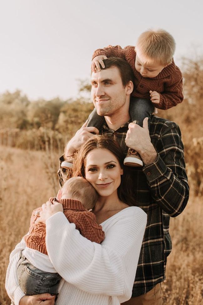 a man and woman holding a baby in their arms