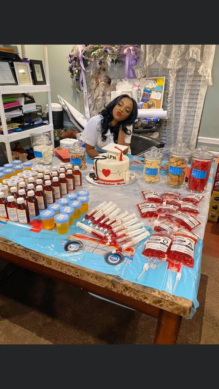 a woman sitting at a table covered in food and condiments with a cake on it