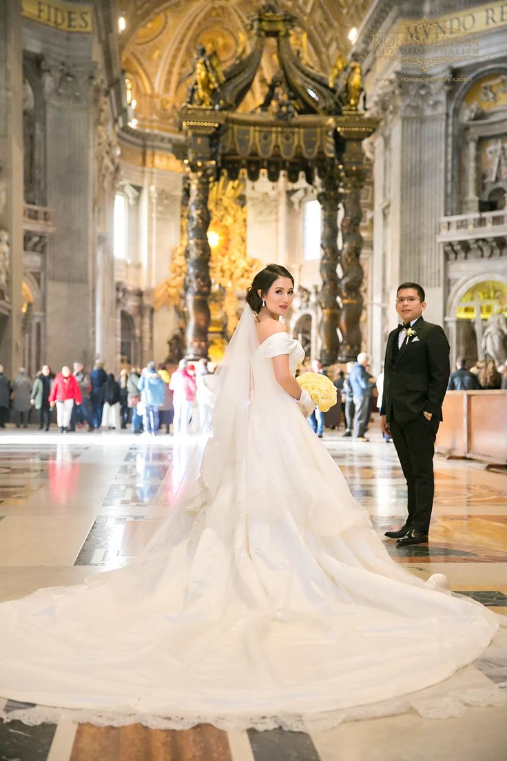 the bride and groom are walking through the cathedral