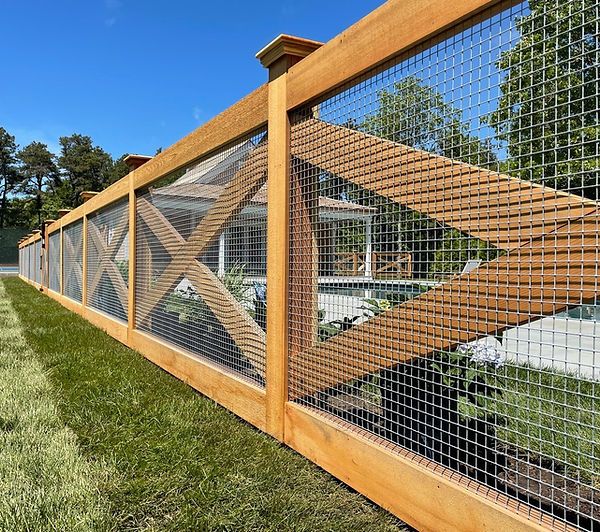 a wooden fence with metal mesh on the top and bottom part, in front of a house