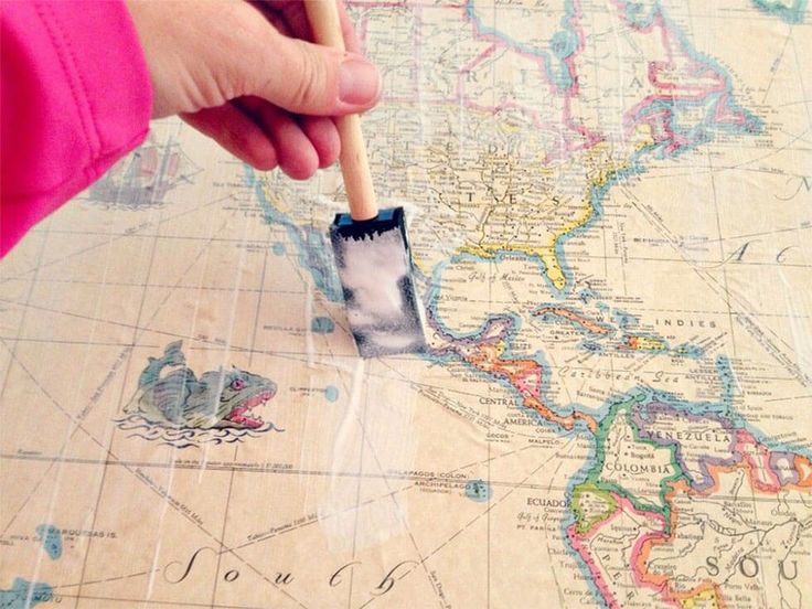 a person is holding a brush over a map