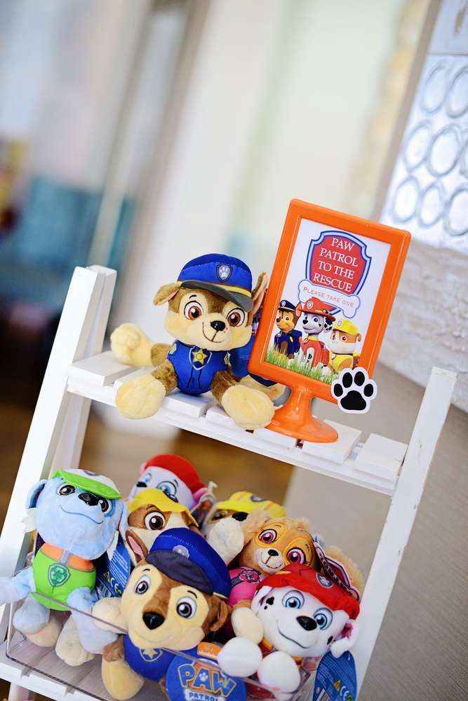 there are many stuffed animals on the shelves in this room and one has a sign that says paw patrol