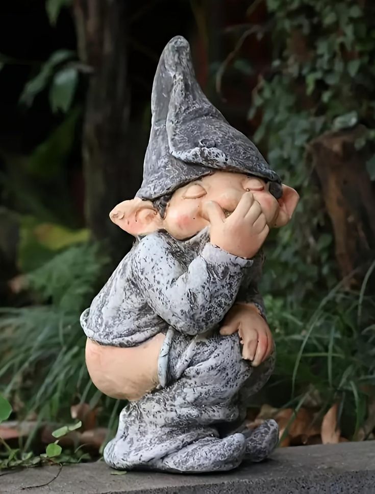 a statue of a little gnome sitting on the ground