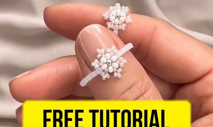 a person holding two small white flowers in their hand with the text free video instructions