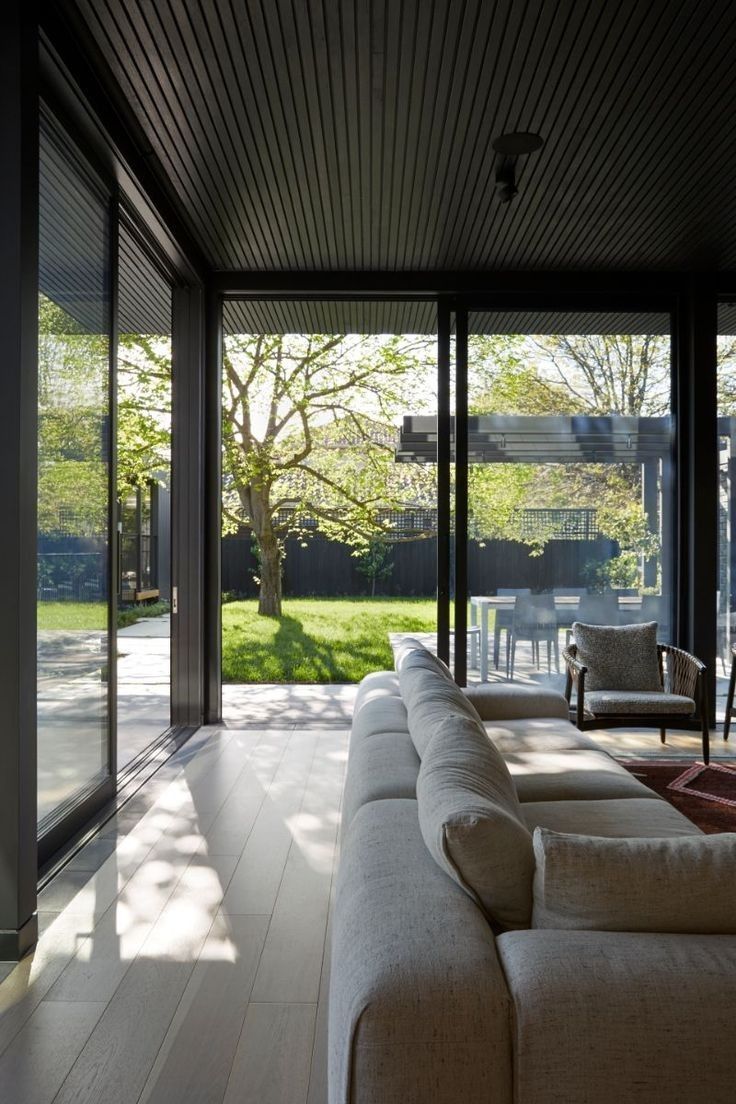 a living room filled with furniture and large windows