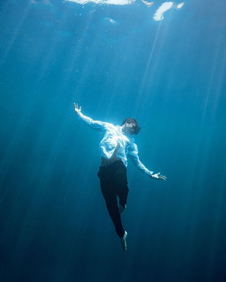 a man floating in the water with his arms outstretched