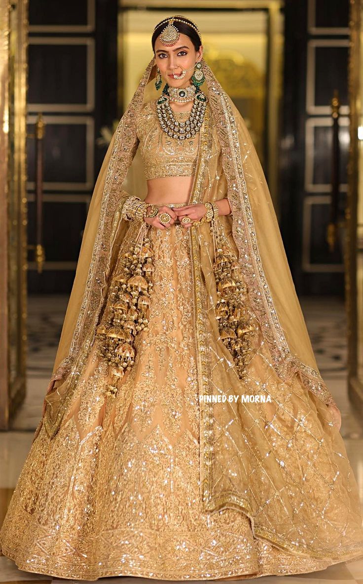 a woman in a gold lehenga and matching jewelry