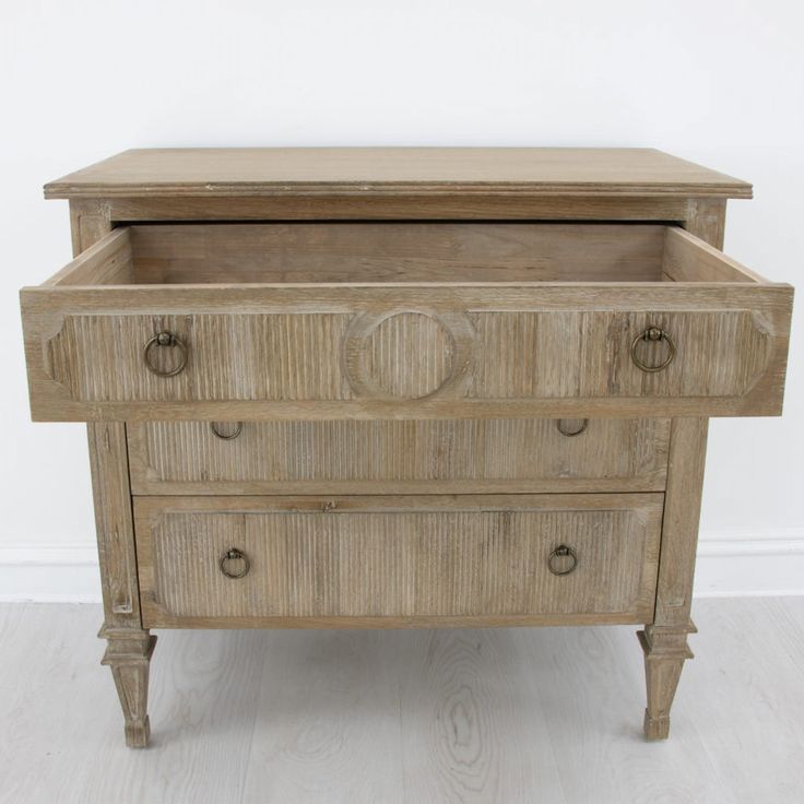 an old wooden dresser with drawers and knobs on the bottom drawer, against a white wall