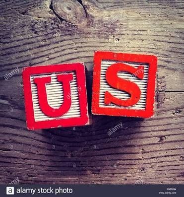 two red blocks with the word us on them sitting on top of a wooden table