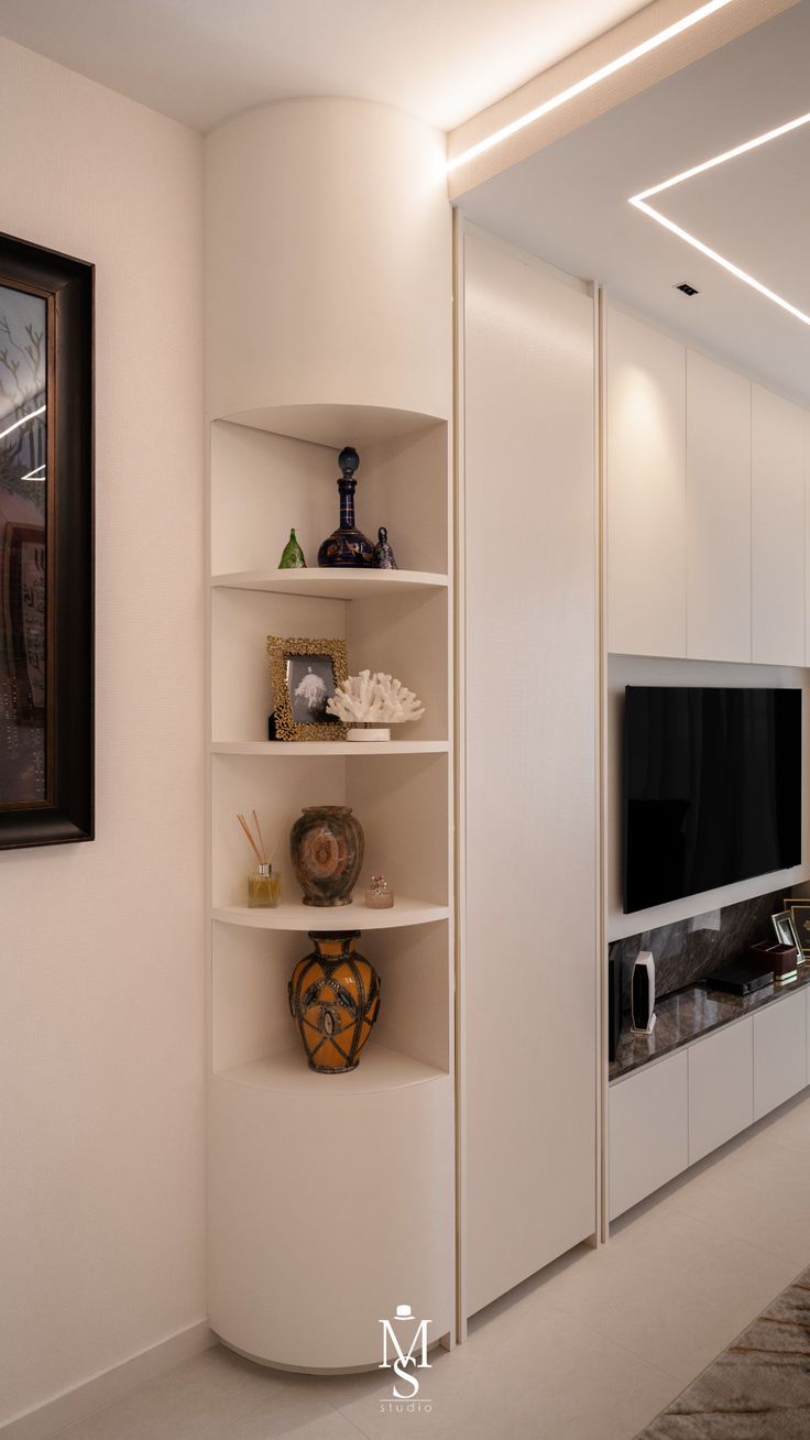 a living room with white walls and shelving unit