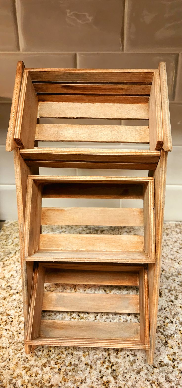 three wooden shelves stacked on top of each other in a room with tile flooring