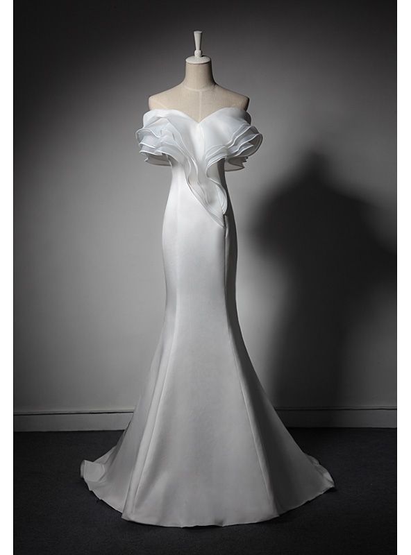 a white wedding dress on a mannequin with an off - the - shoulder neckline