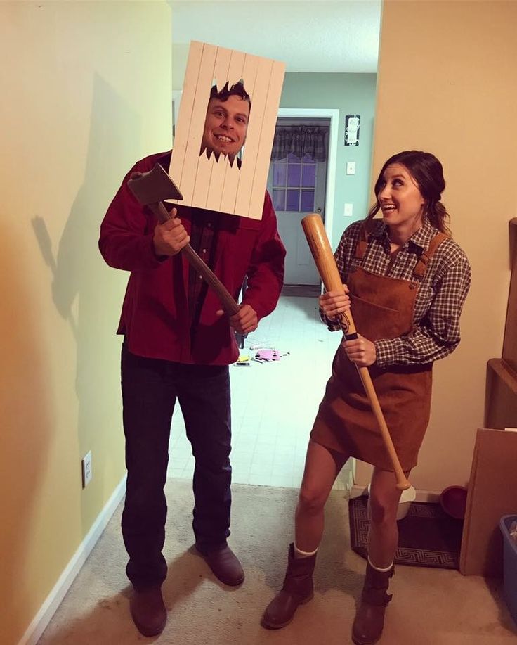 a man and woman dressed up in costumes holding baseball bats while standing next to each other