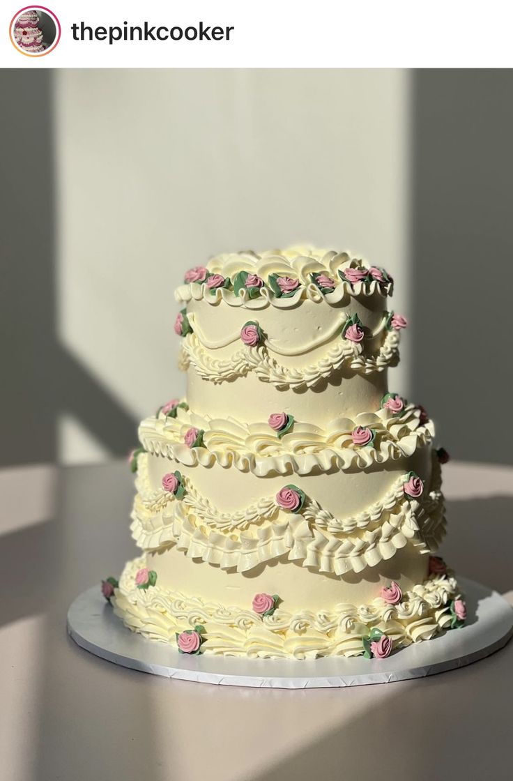 a three tiered wedding cake with pink flowers on it