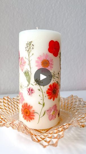 a white candle with red and pink flowers on it