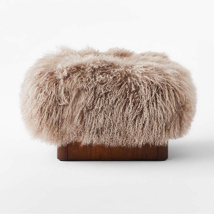 a furry stool on a wooden stand against a white background in the shape of a footstool