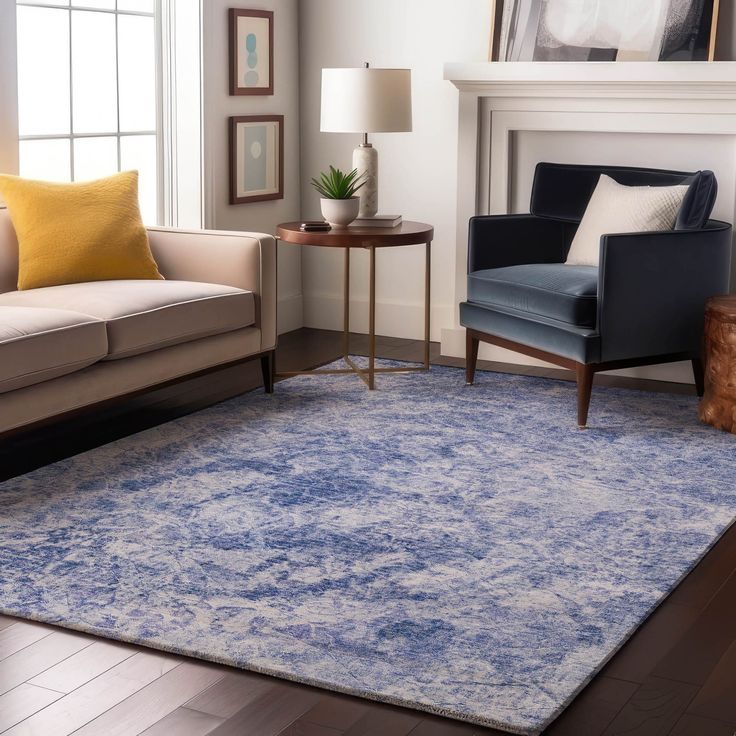 a living room filled with furniture and a blue rug on top of a hard wood floor