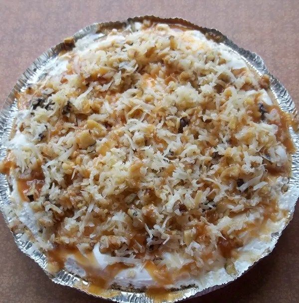 an uncooked pie sitting on top of a table covered in cheese and toppings