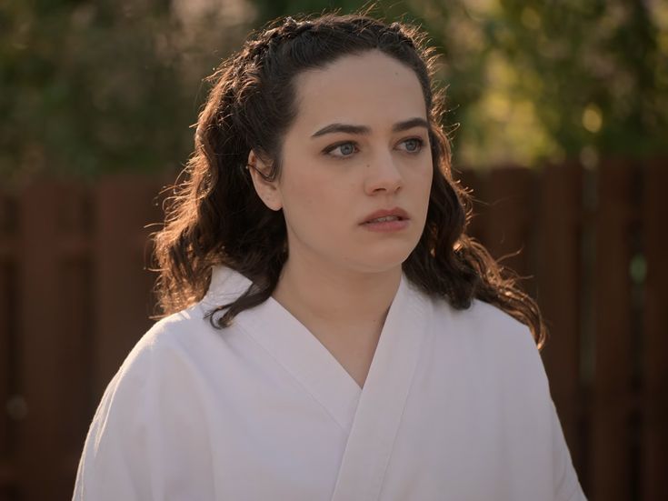 a woman with long hair wearing a white robe