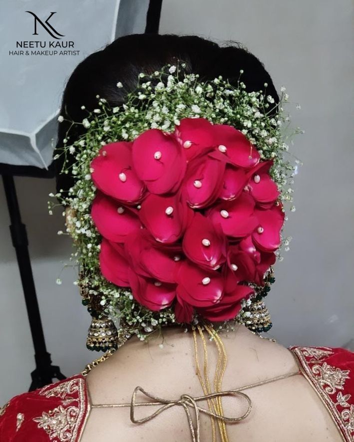 the back of a woman's head with flowers in her hair and pearls on it