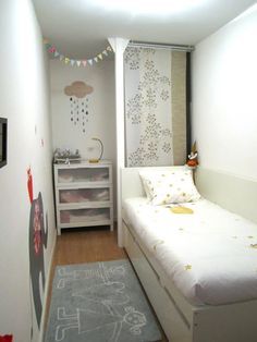 a small bedroom with a bed, dresser and rug