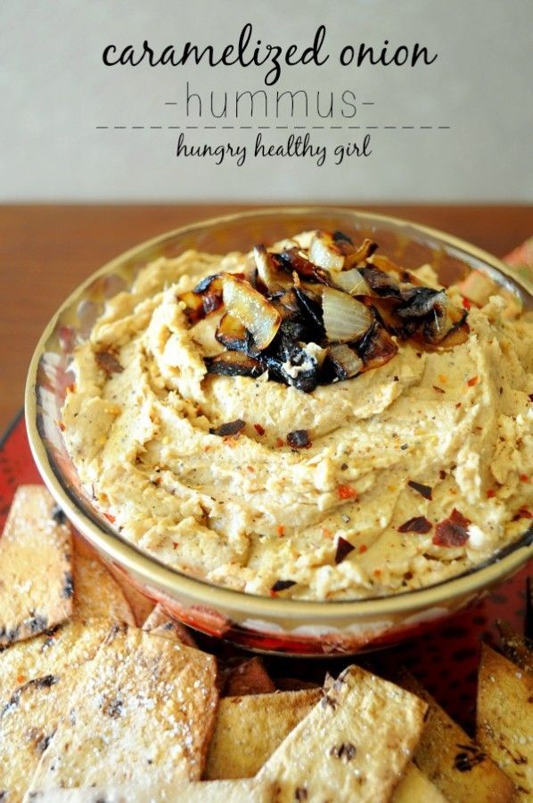 a bowl filled with hummus surrounded by crackers