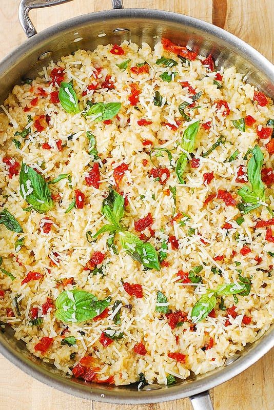 a pan filled with rice and vegetables on top of a wooden table