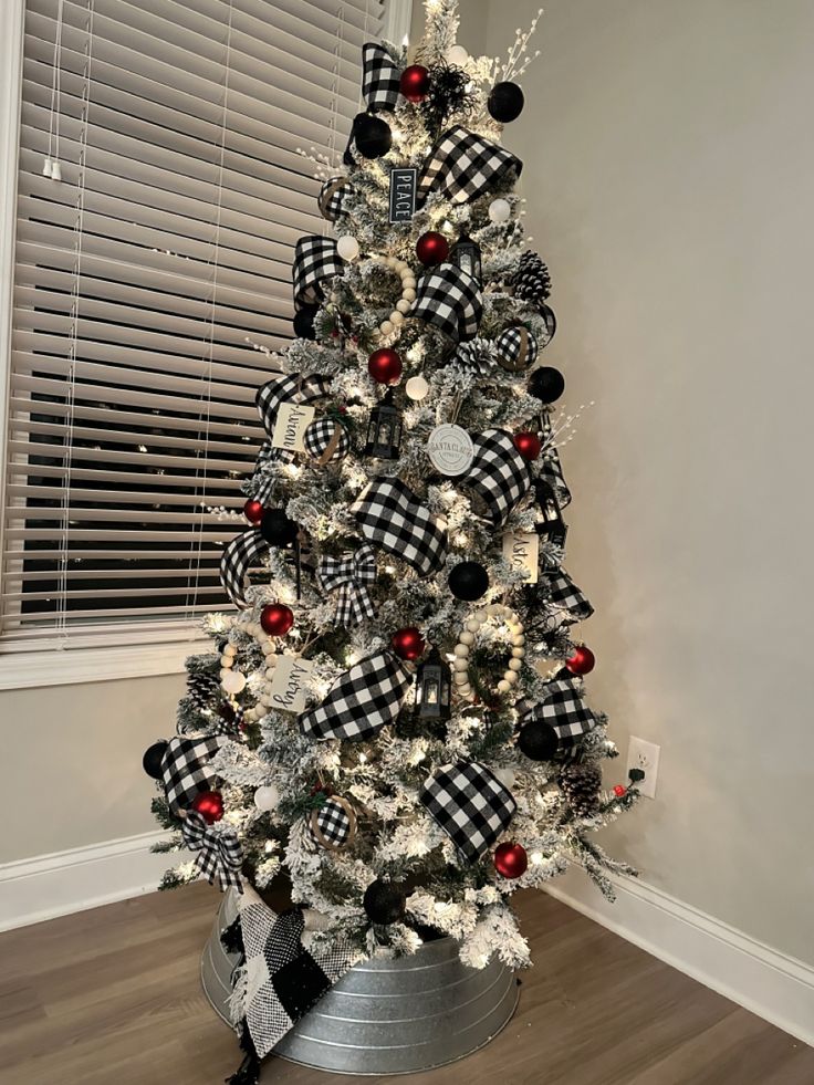 a white christmas tree with black and red ornaments