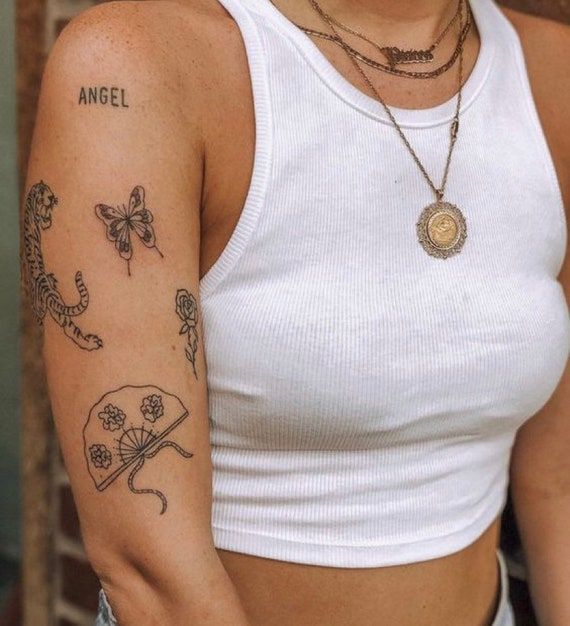 a woman wearing a white tank top with tattoos on her arm