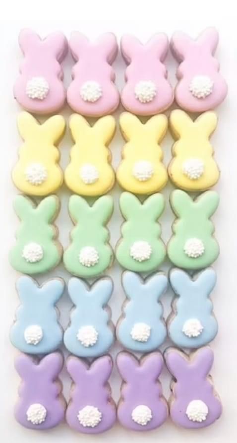 many different colored bunny shaped cookies on a white surface