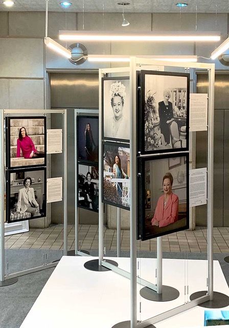 a group of pictures on display in a room with tile flooring and white walls