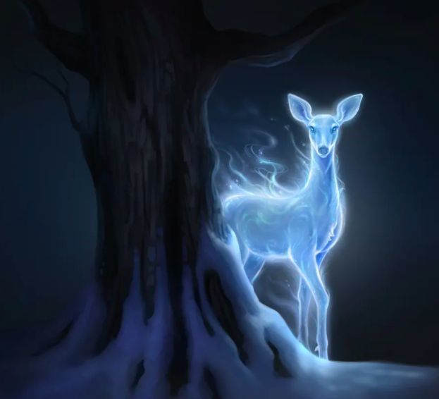 a deer standing next to a tree in the snow at night with light coming from its antlers