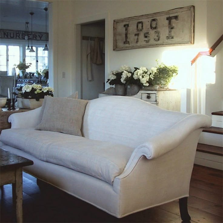 a white couch sitting in the middle of a living room