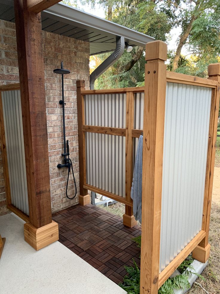 an outdoor shower area with brick and wood