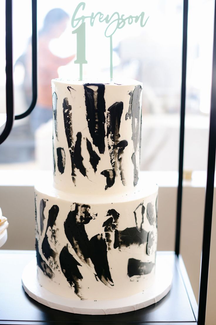 a three tiered cake with black and white icing