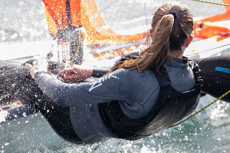 a woman riding on top of a boat in the ocean