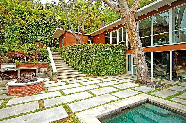 a house with a pool in front of it and stairs leading up to the outside