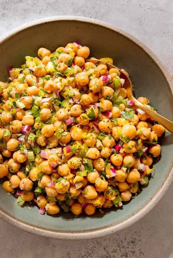 a bowl filled with chickpeas, onions and cilantro on top of a table