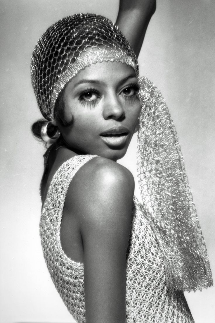 a black and white photo of a woman wearing a head scarf