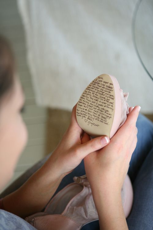 a woman holding a heart shaped object with writing on it